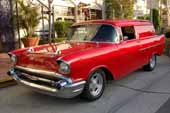 Front view of a red beautifully restored 1957 chevy sedan delivery